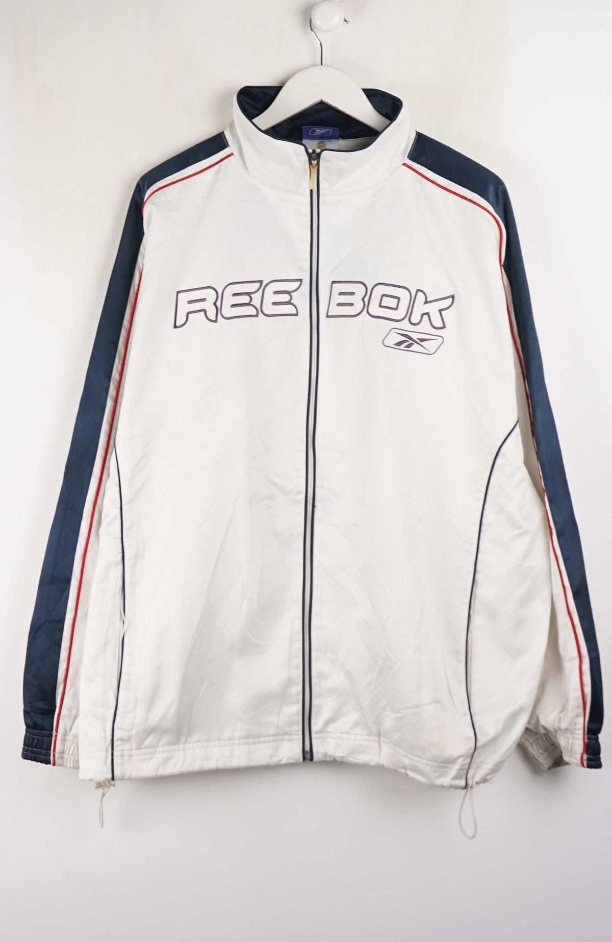 White Reebok jacket with blue and red accents on a white background