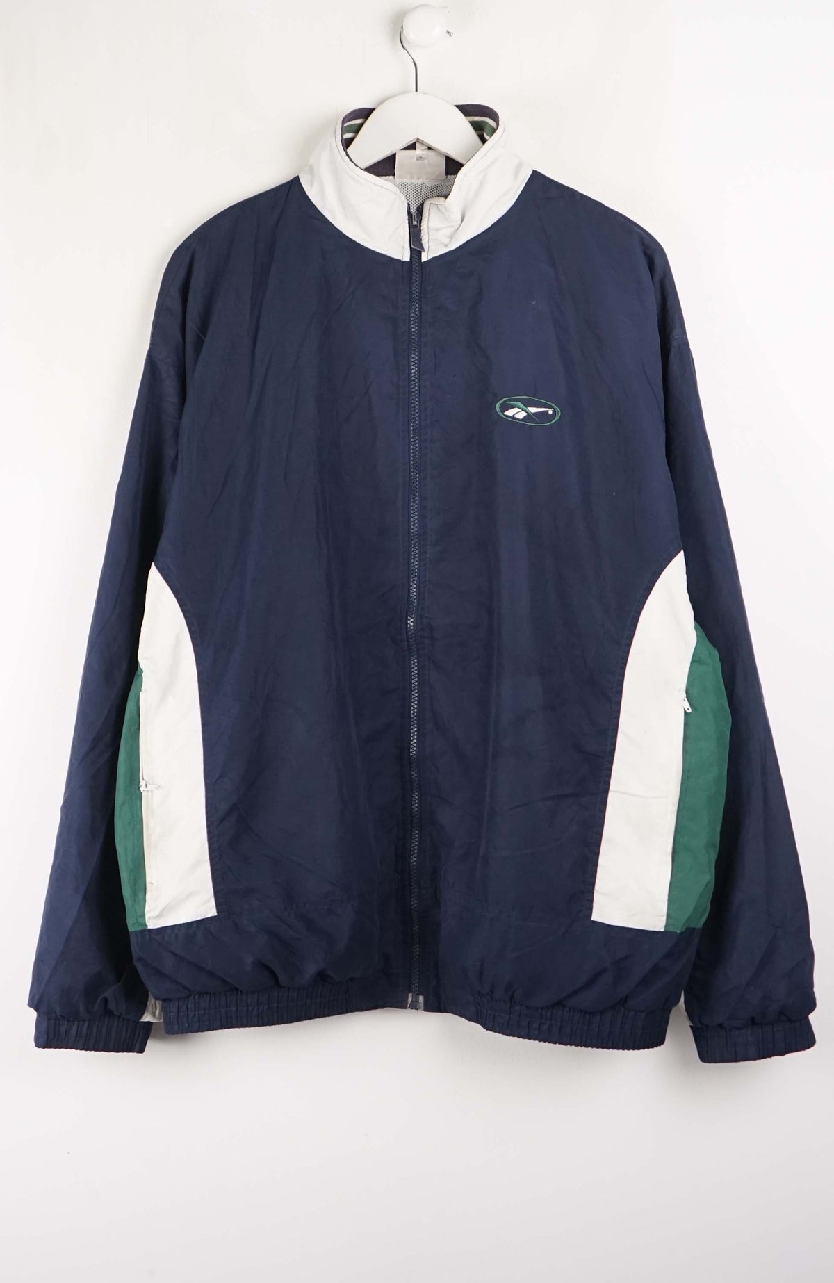 Navy blue jacket with white and green accents on a hanger against a white background