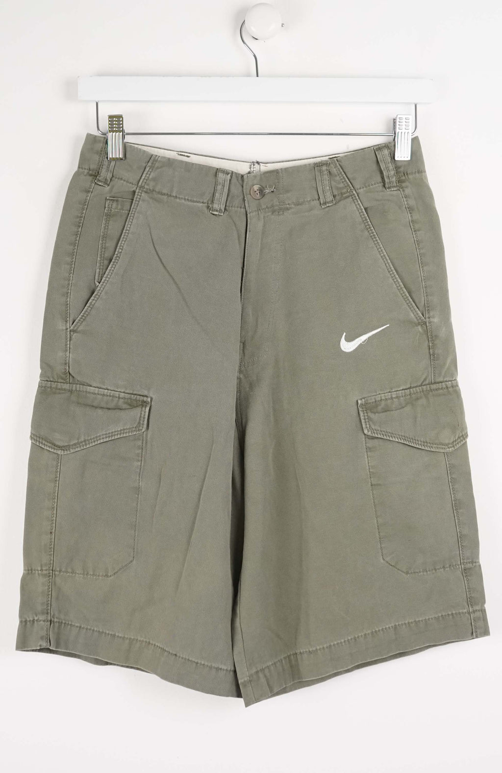 Green cargo shorts with Nike logo on a white background