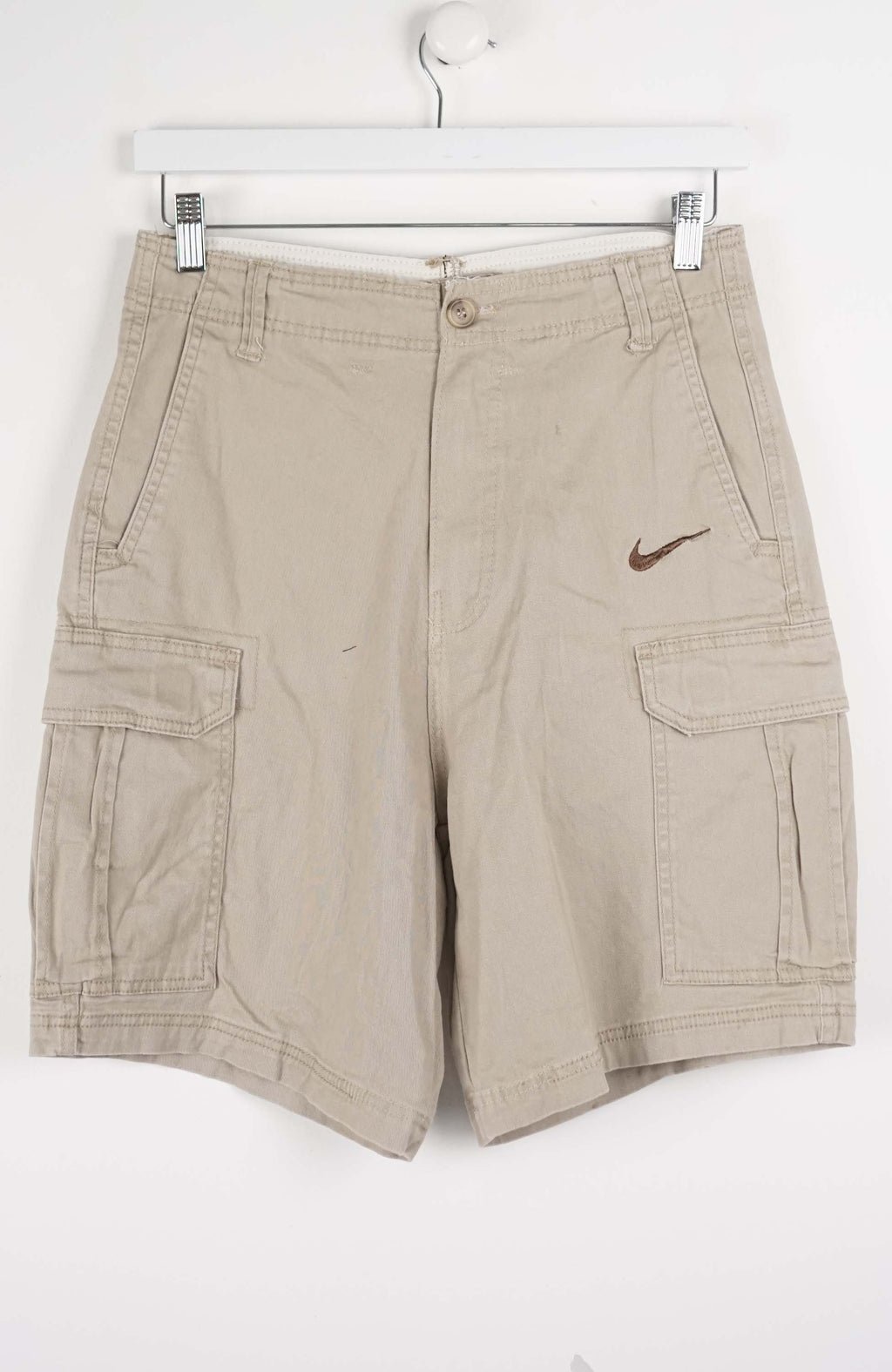 Beige cargo shorts with a Nike logo on a white background