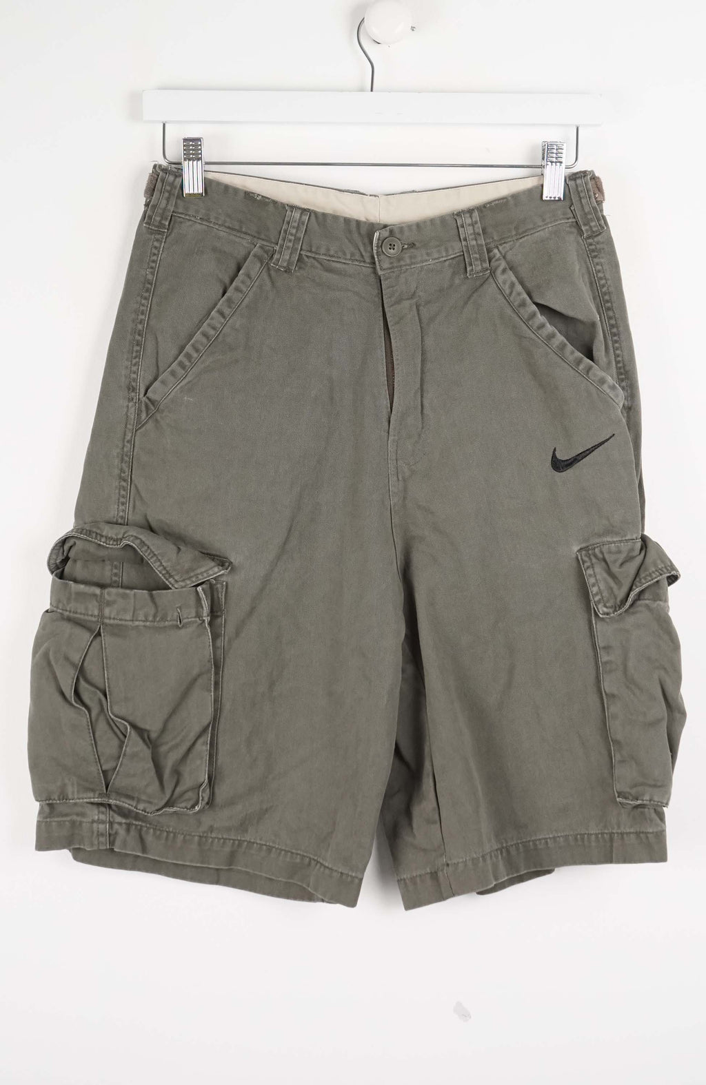 Green cargo shorts with a Nike logo on a white background