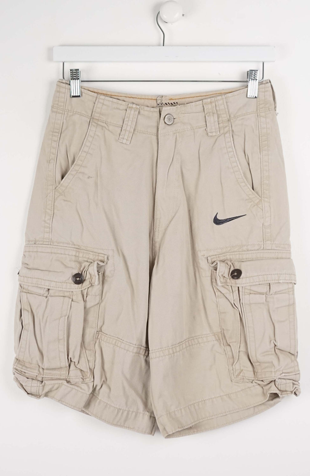 Beige cargo shorts with a Nike logo on a white background