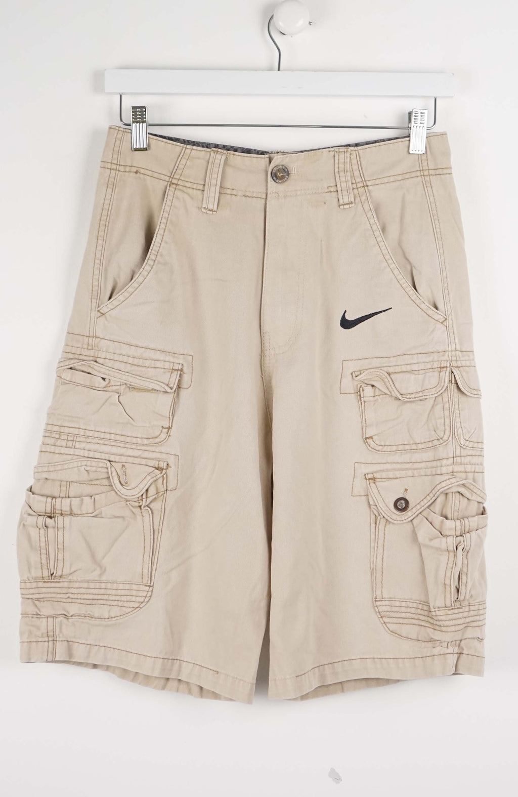 Beige cargo shorts with a Nike logo on a white background