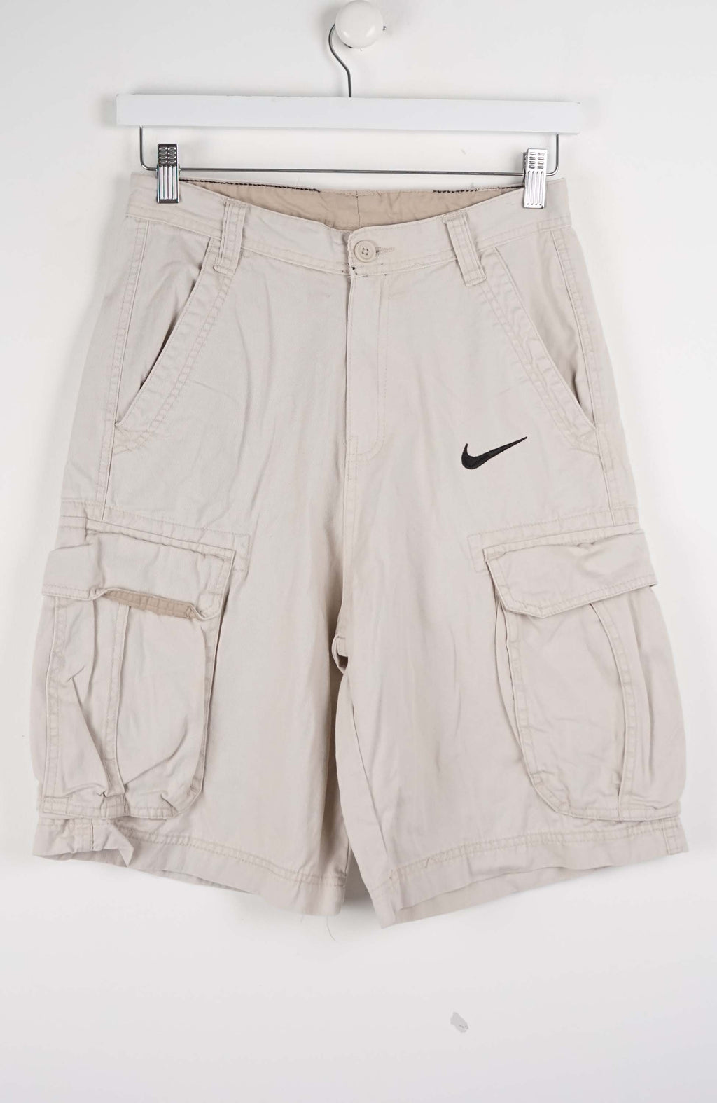 Beige cargo shorts with a Nike logo on a white background