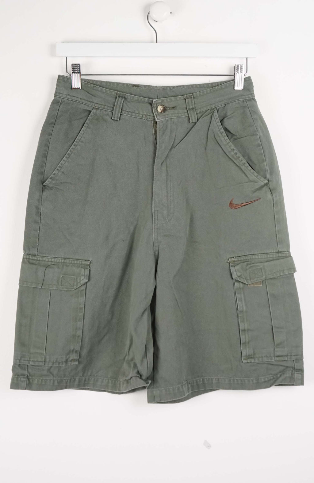 Green cargo shorts with a Nike logo on a white background