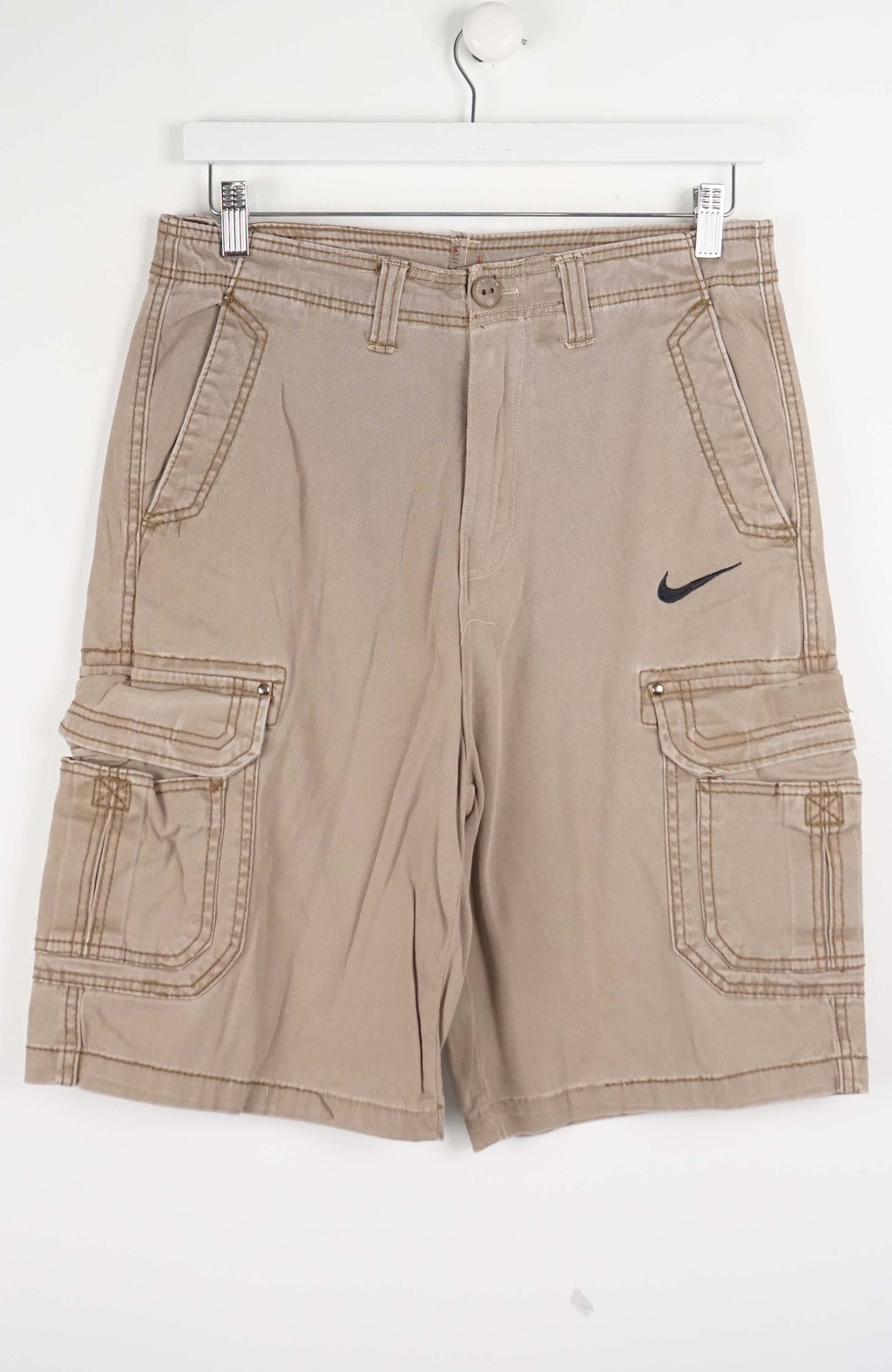 Beige cargo shorts with a Nike logo on a white background