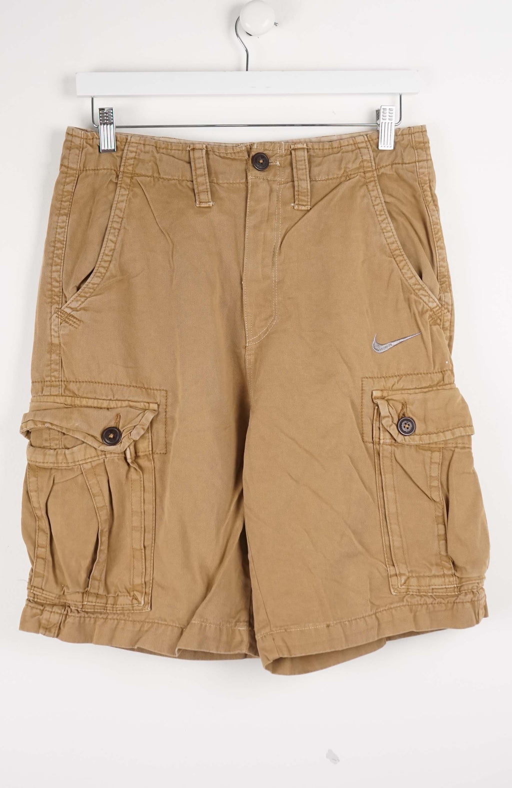 Beige cargo shorts with a Nike logo on a white background