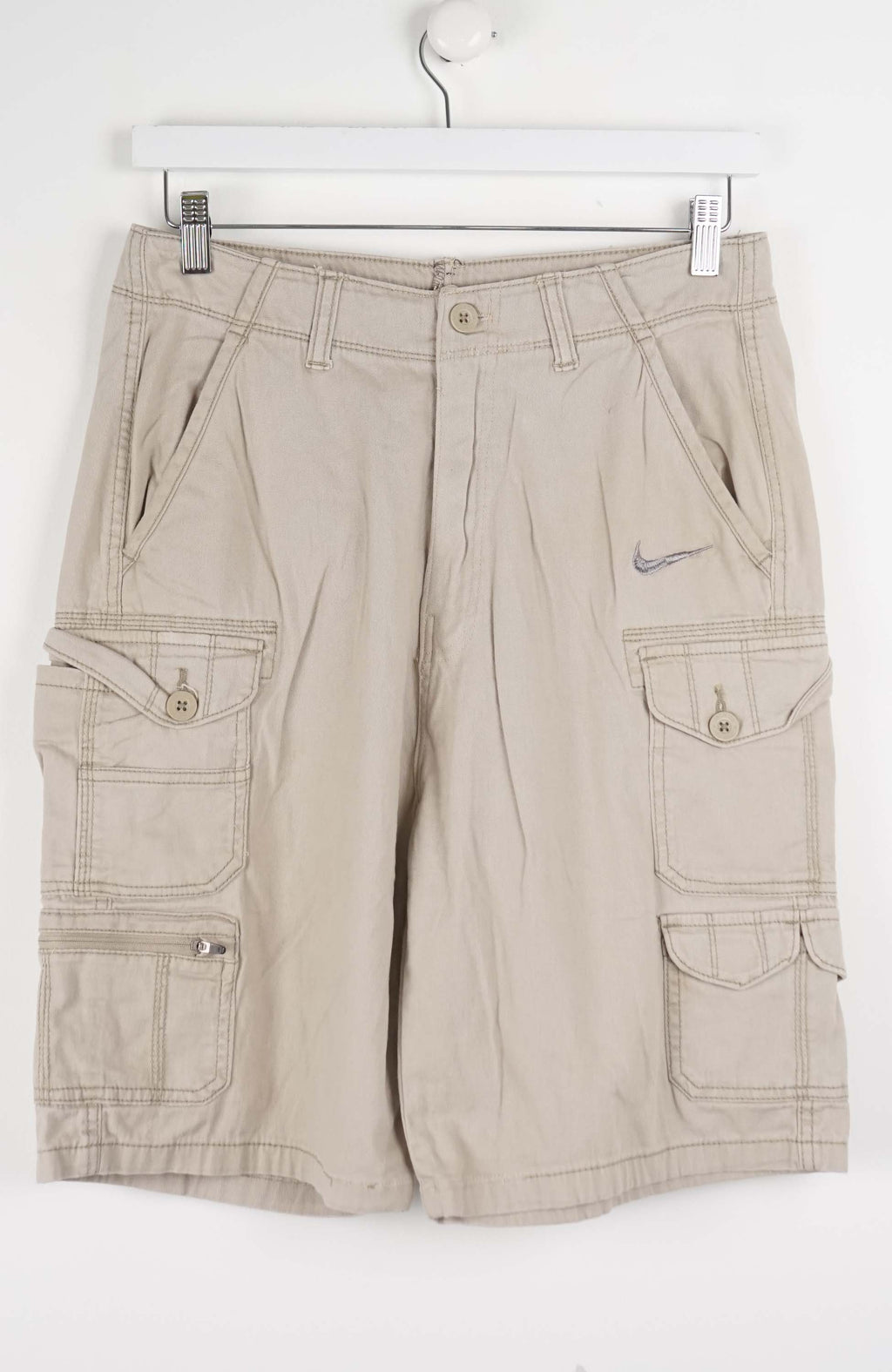 Beige cargo shorts with a Nike logo on a white background