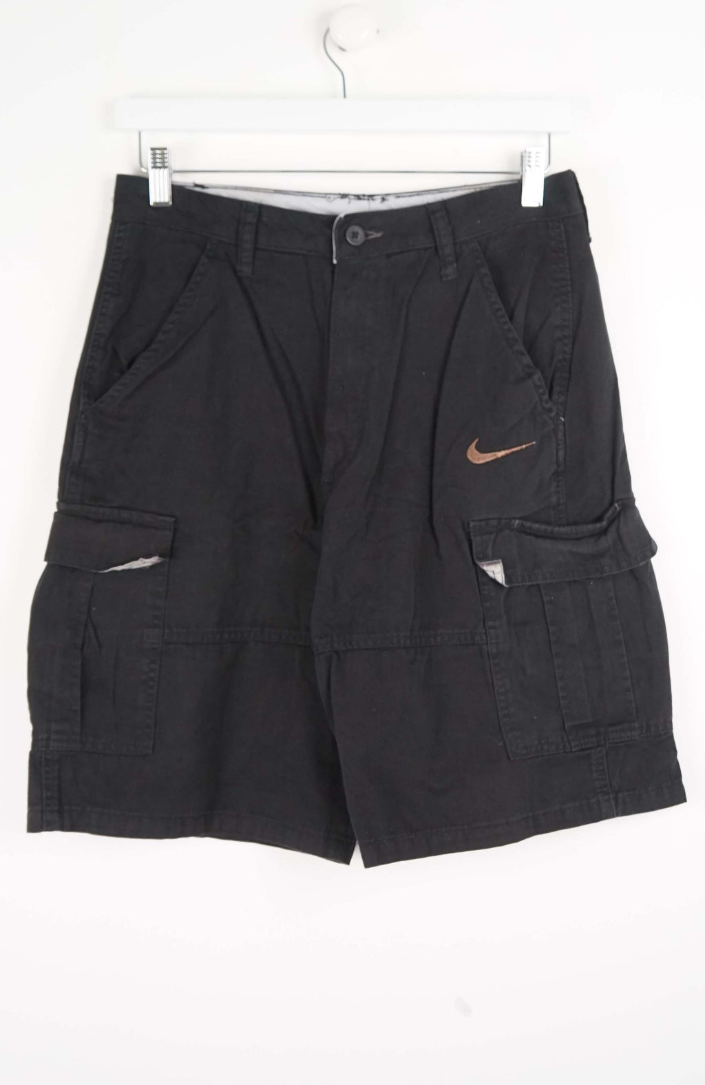 Black cargo shorts with a Nike logo on a white background
