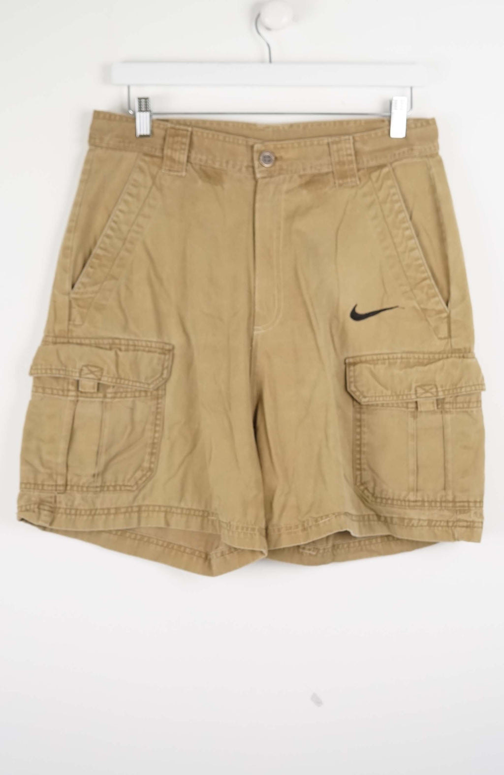 Beige cargo shorts with a Nike logo on a white background