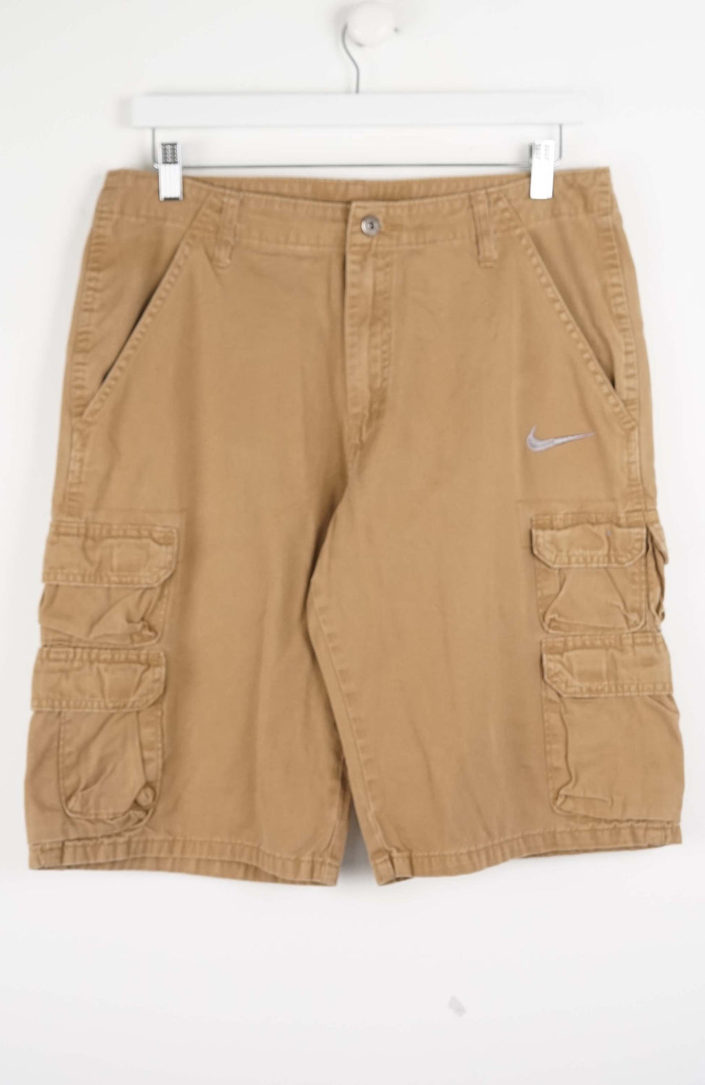 Tan cargo shorts with a Nike logo on a white background