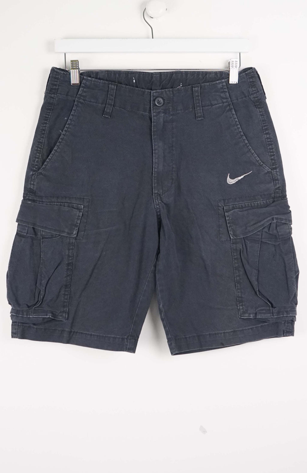 Blue cargo shorts with a Nike logo on a white background