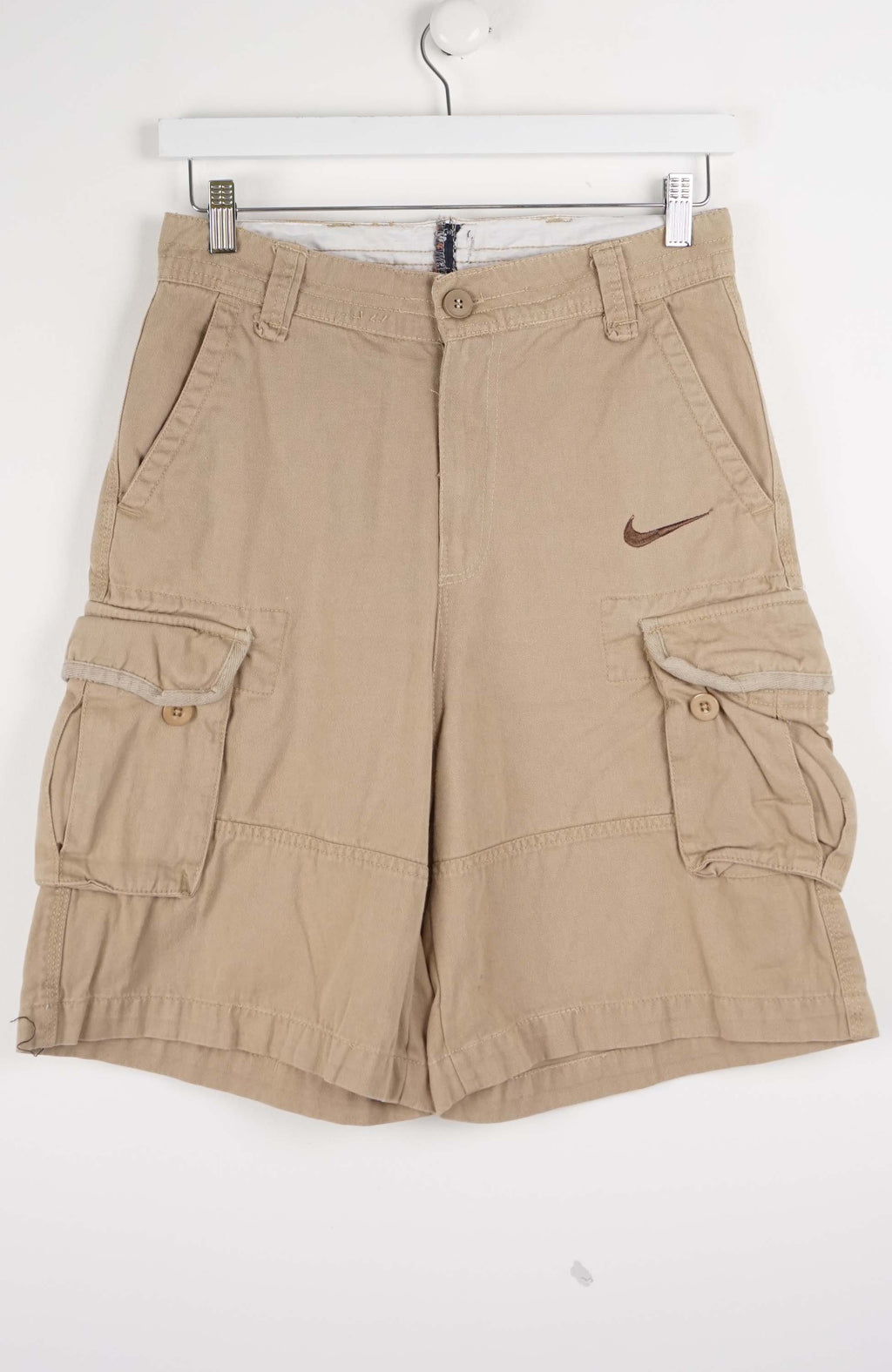 Beige cargo shorts with a Nike logo on a white background