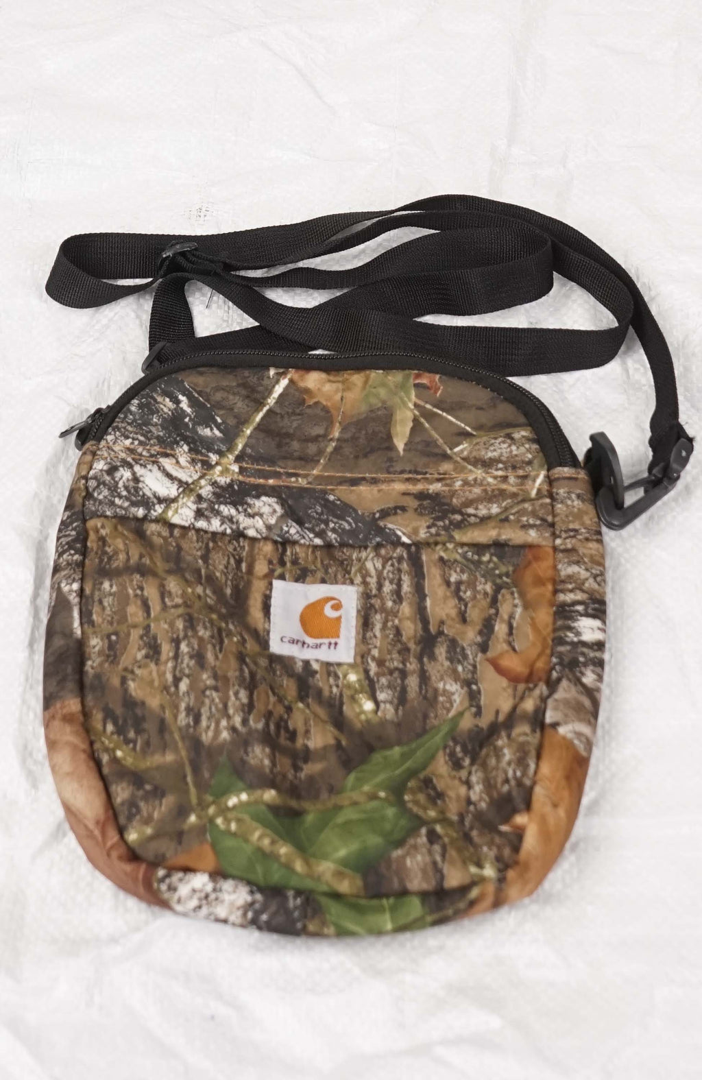 Camouflage crossbody bag with Carhartt logo on a white background