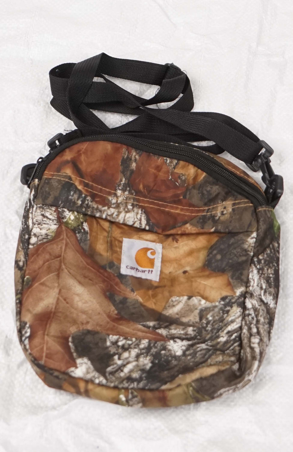 Camouflage crossbody bag with a visible brand logo on a white background