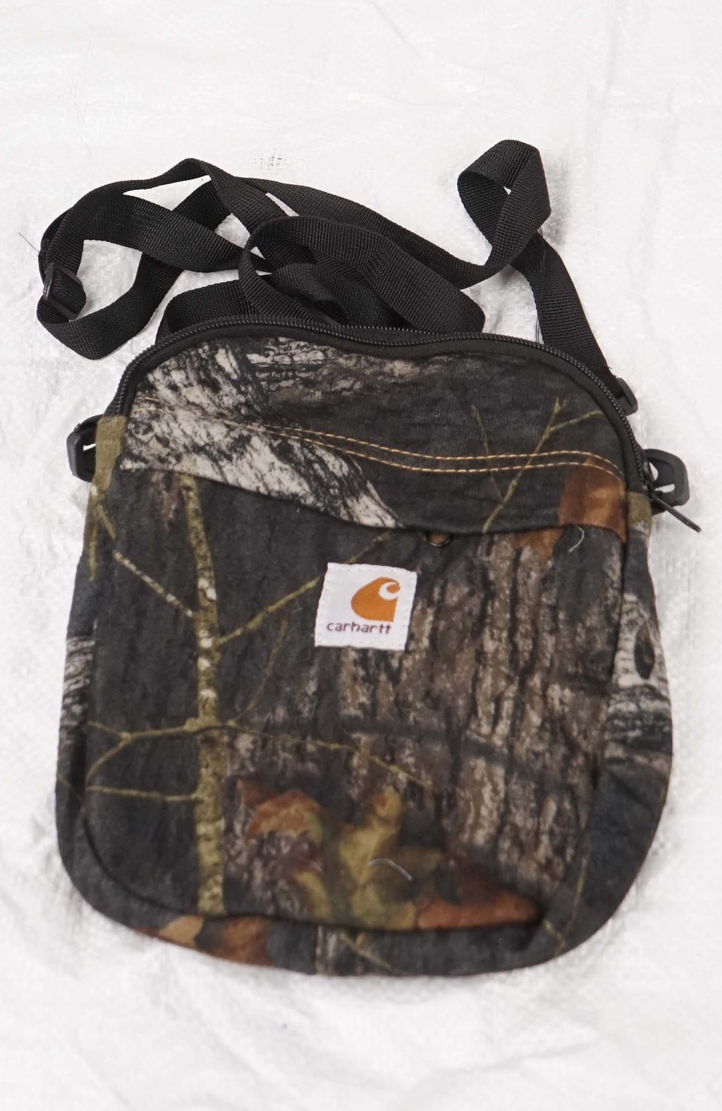 Camouflage crossbody bag with Carhartt logo on a white background