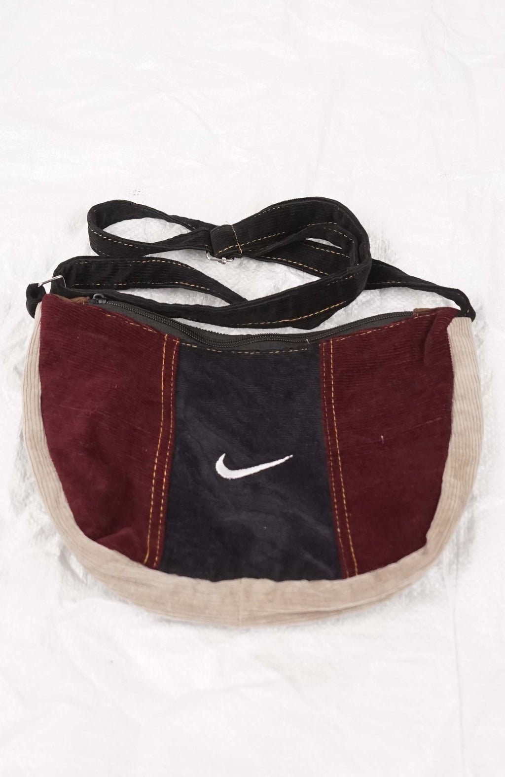 Maroon and black bag with a Nike logo on a white background