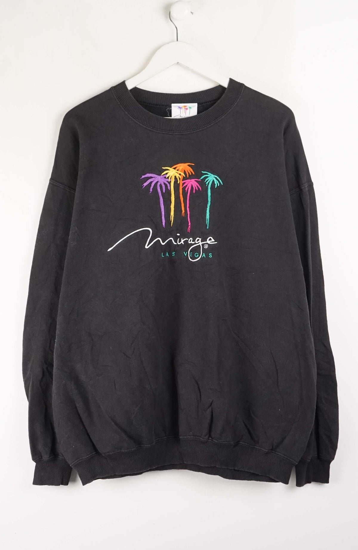 Black sweatshirt with colorful palm tree design and 'Mirage Las Vegas' text on a white background