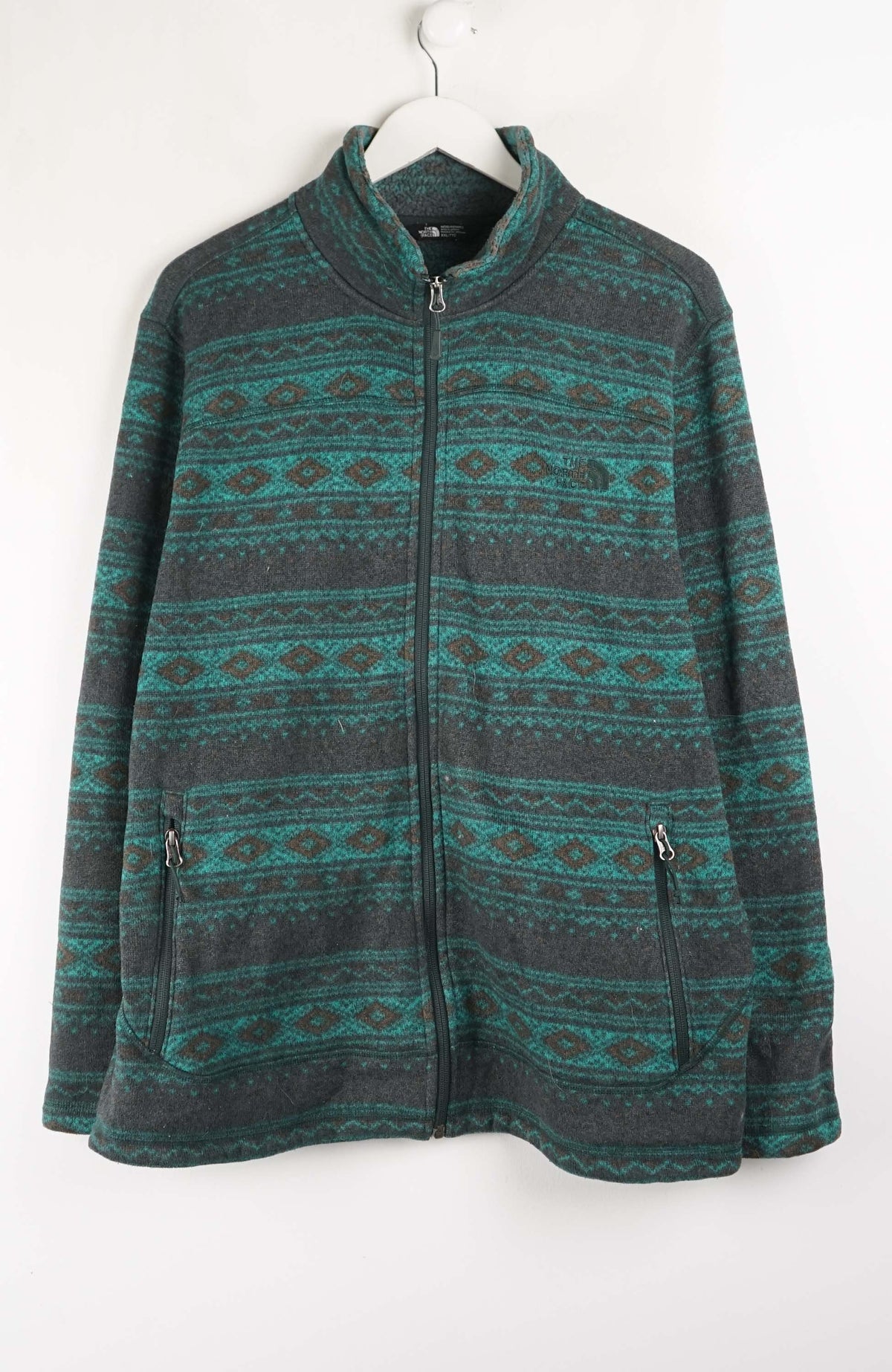 Green and gray patterned jacket on a white hanger