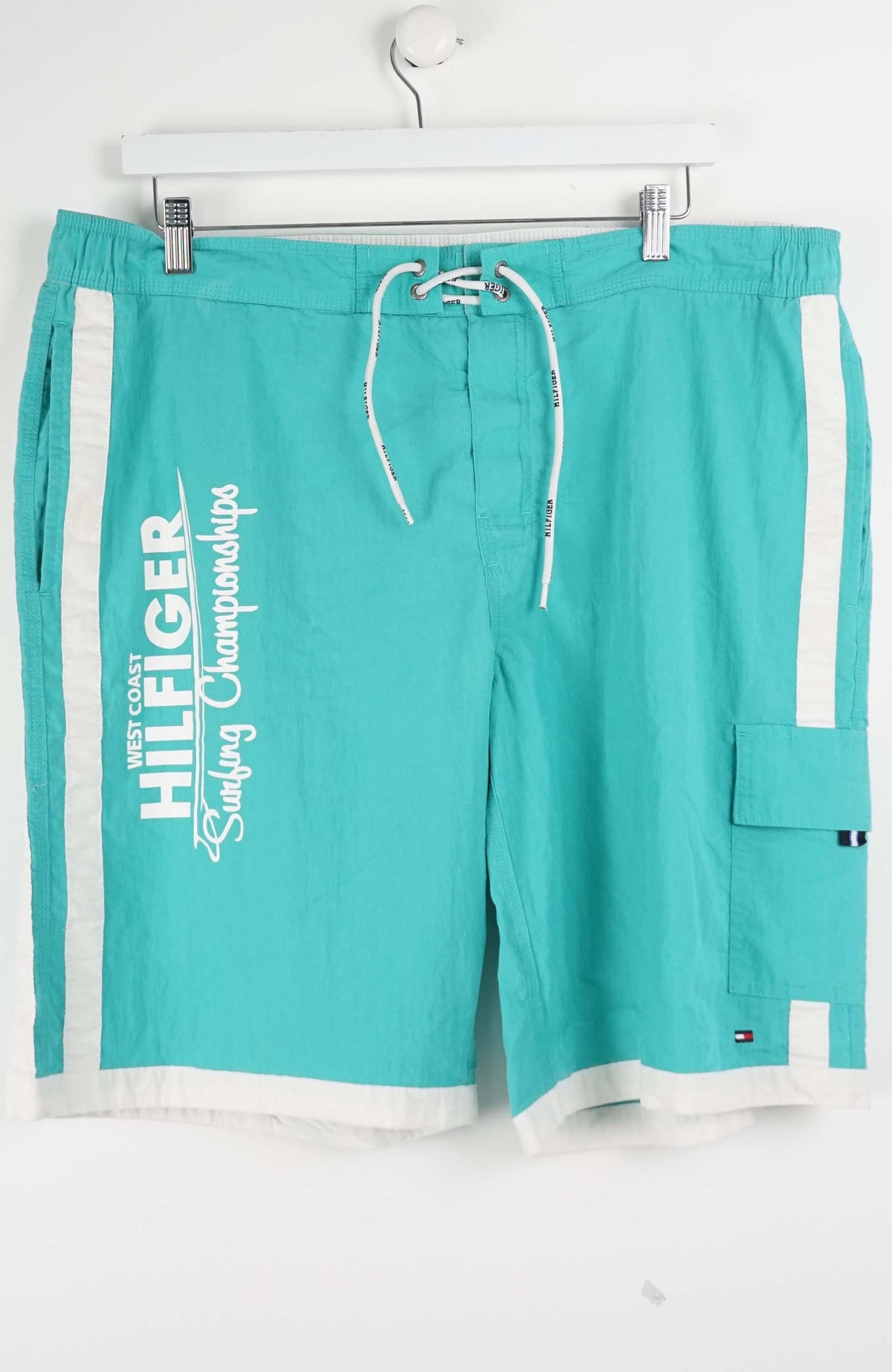Turquoise shorts with white drawstring and side panels on a white background