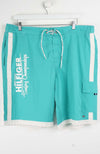 Turquoise shorts with white drawstring and side panels on a white background