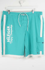 Turquoise shorts with white drawstring and side panels on a white background