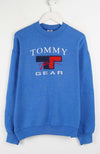 Blue Tommy Gear sweatshirt on a white hanger against a white background