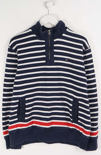 Navy and white striped sweater with a red stripe on a hanger against a white background