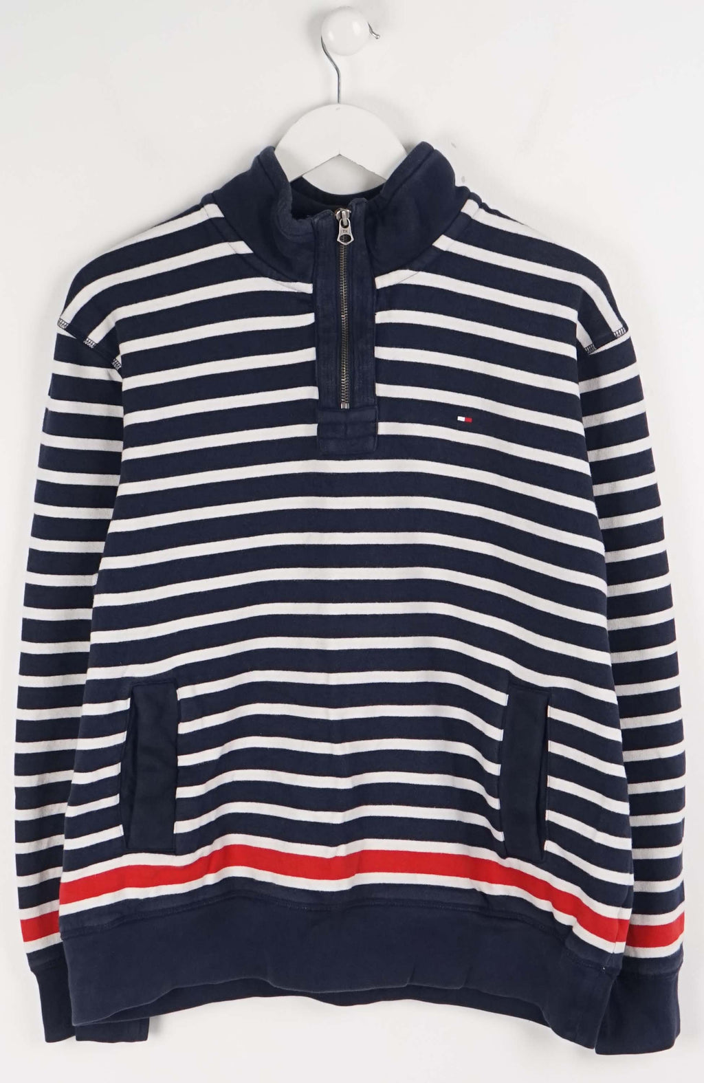 Navy and white striped sweater with a red stripe on a hanger against a white background