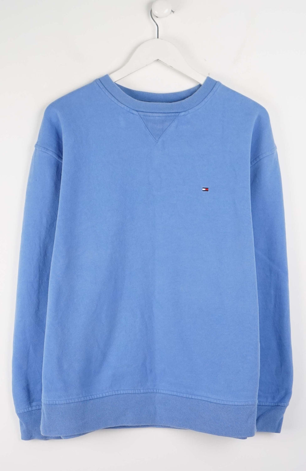 Blue sweatshirt on a white hanger against a white background