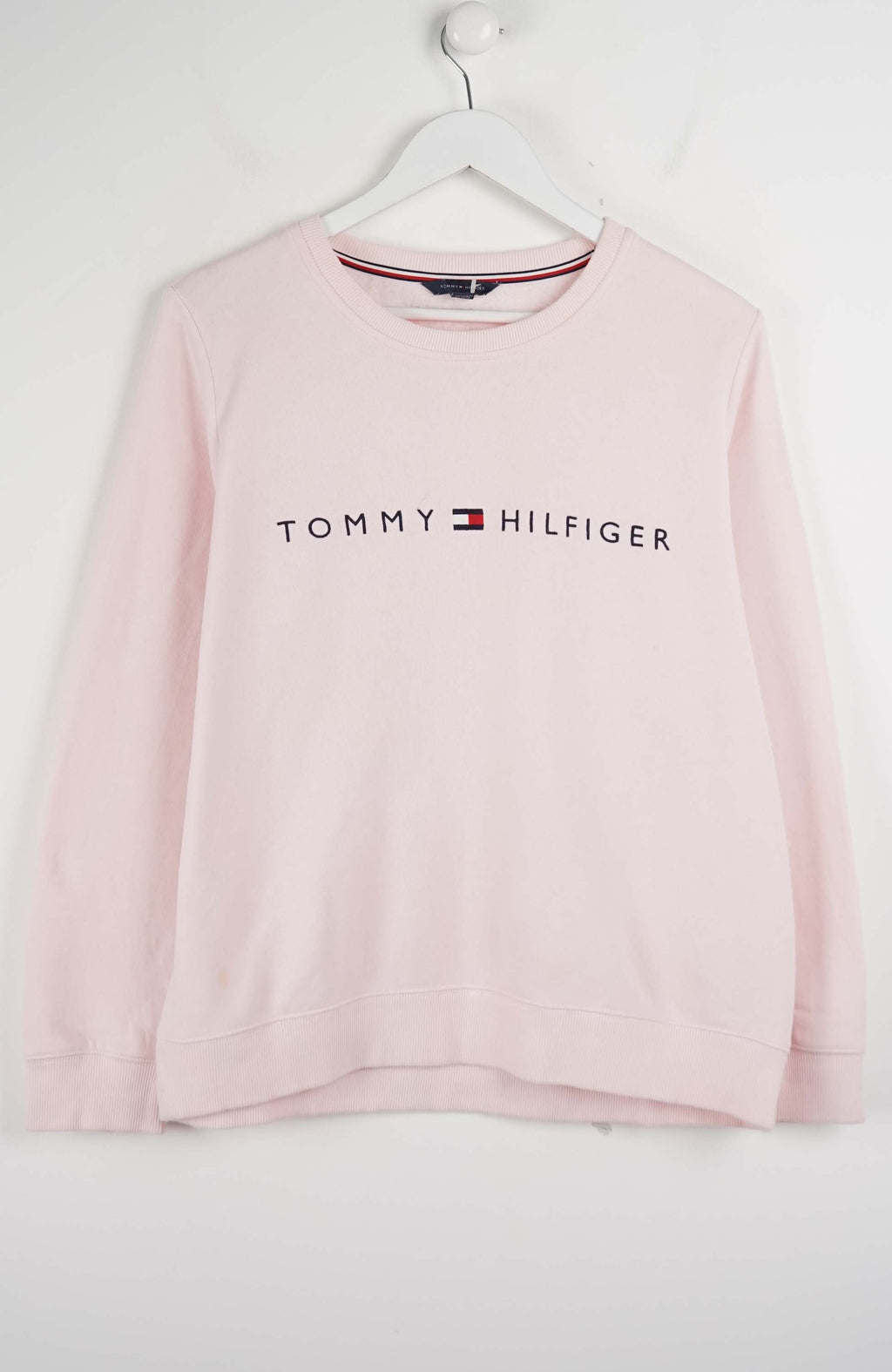 Pink Tommy Hilfiger sweatshirt on a white hanger