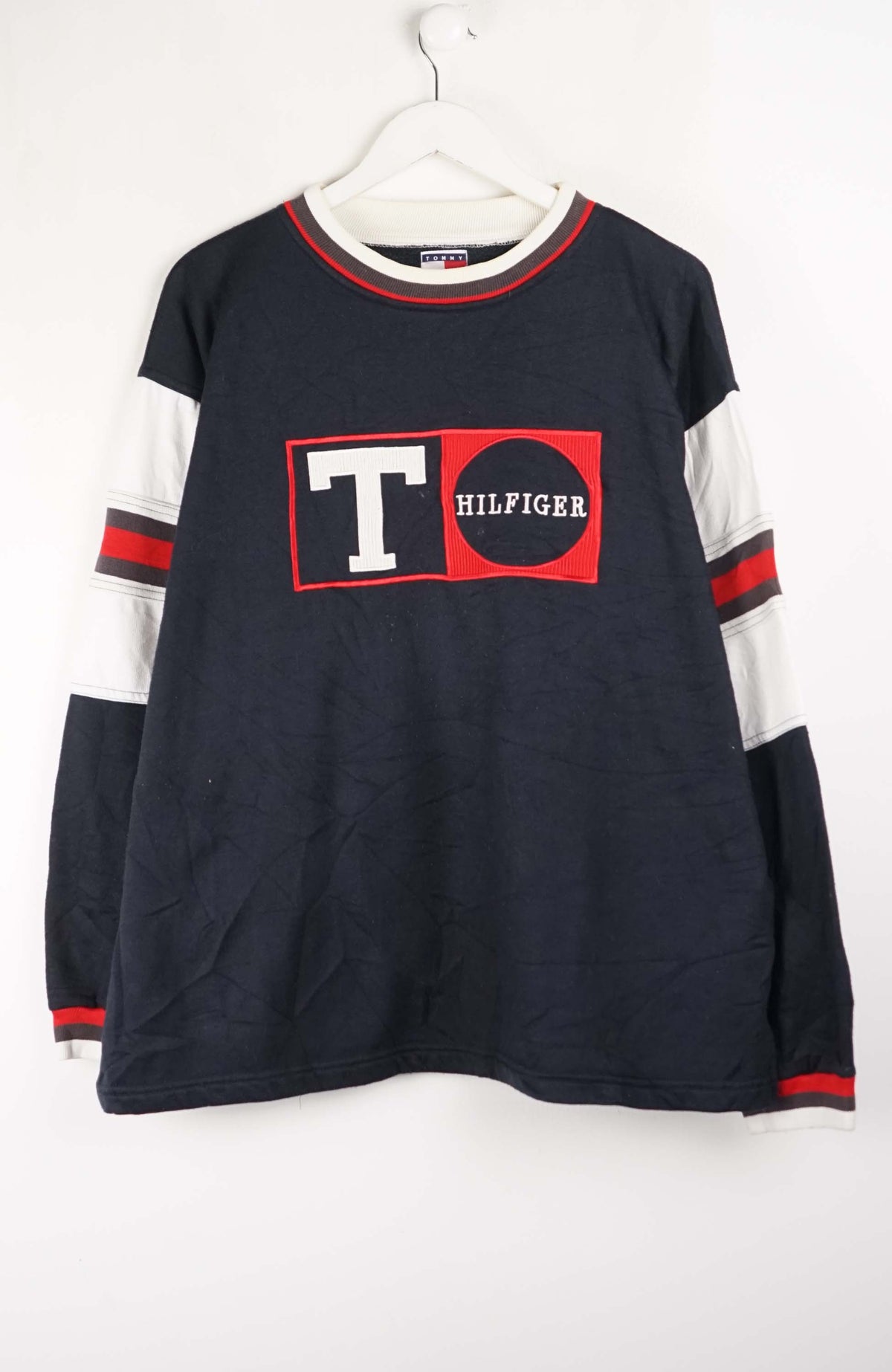 Navy long-sleeve shirt with red and white accents and Tommy Hilfiger logo on a white background