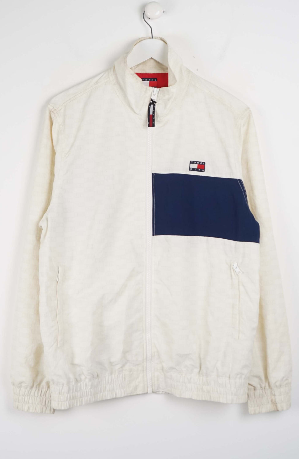 White jacket with a navy pocket on a white background