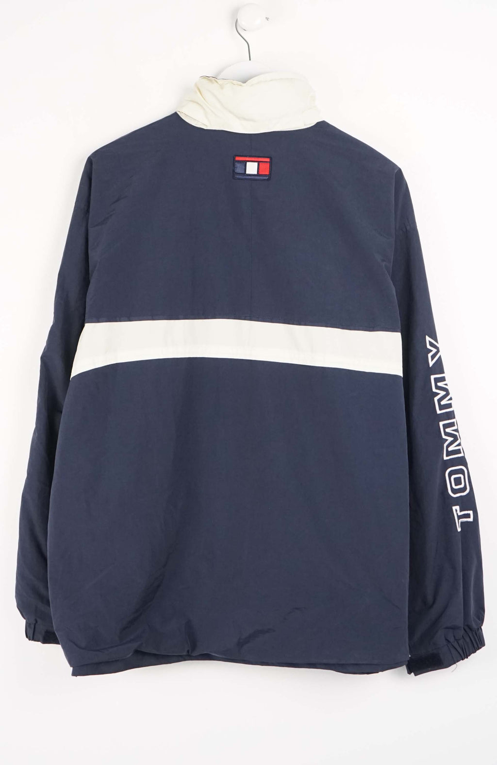 Navy jacket with white accents and 'Tommy' branding on a white background