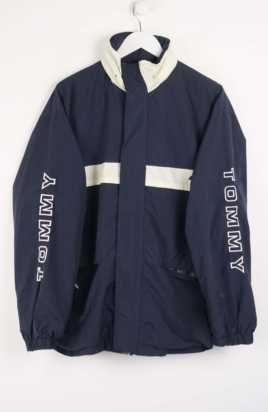 Navy jacket with white accents and 'Tommy' branding on a white background