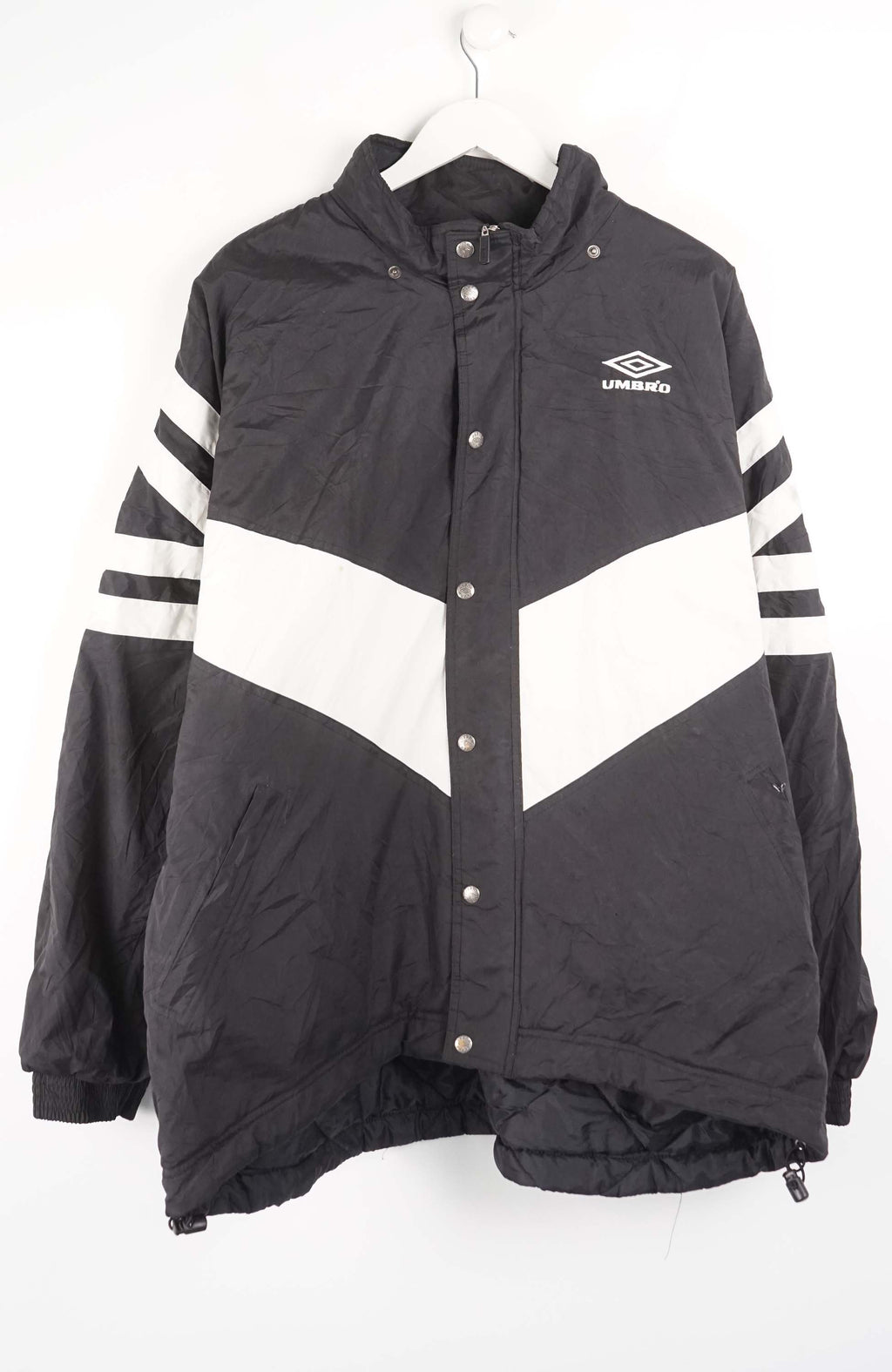 Black and white jacket with striped sleeves on a hanger against a white background