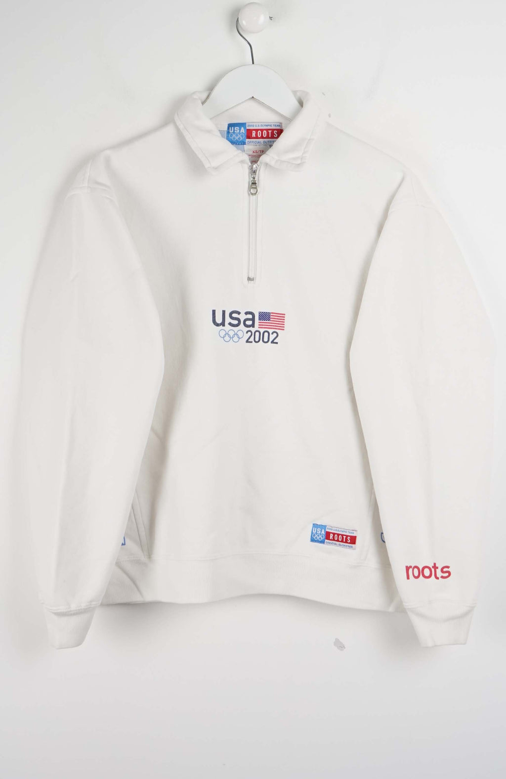 White pullover with 'USA 2002' and 'roots' branding on a white background