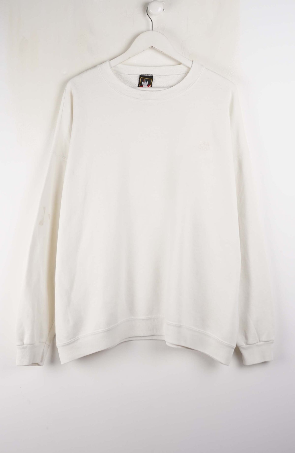 White sweatshirt on a hanger against a white background